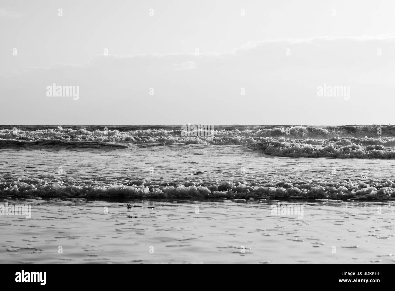 Di medie dimensioni onde infrangersi sulla spiaggia durante il tramonto. Foto Stock