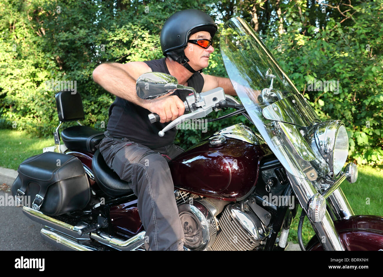 Un uomo di mezza età è in sella a una motocicletta. Foto Stock