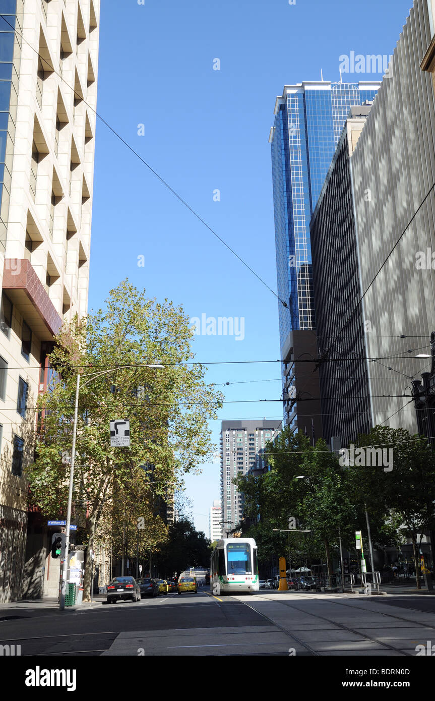 Traffico tranviario alberi e alto grattacielo edifici su Collins Street Melbourne Australia Foto Stock