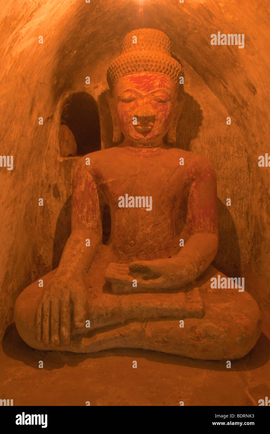 In pietra scolpita statua del Buddha in una nicchia ad arco in una cripta sotto il famoso tempio Sit-Thaung vicino a Mrauk U, Rakhine unito, Weste Foto Stock