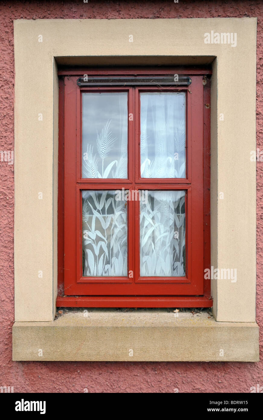 Croce bloccate sul telaio di una finestra con tendine come visto dall'esterno. Foto Stock