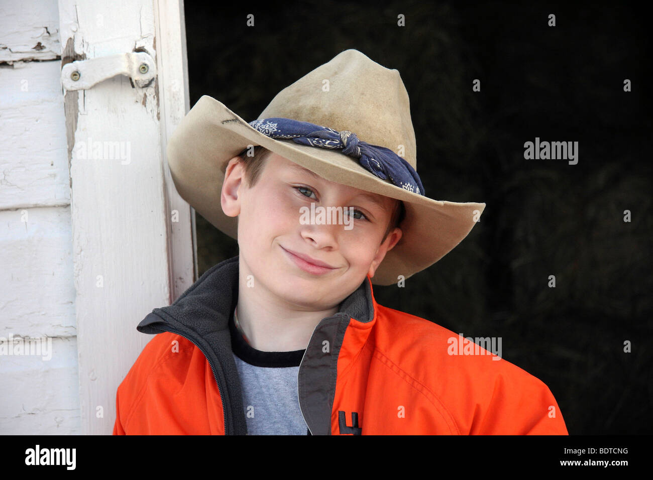 Giovani cowboy di fronte western fienile nel cappello da cowboy e giacca  rossa Foto stock - Alamy