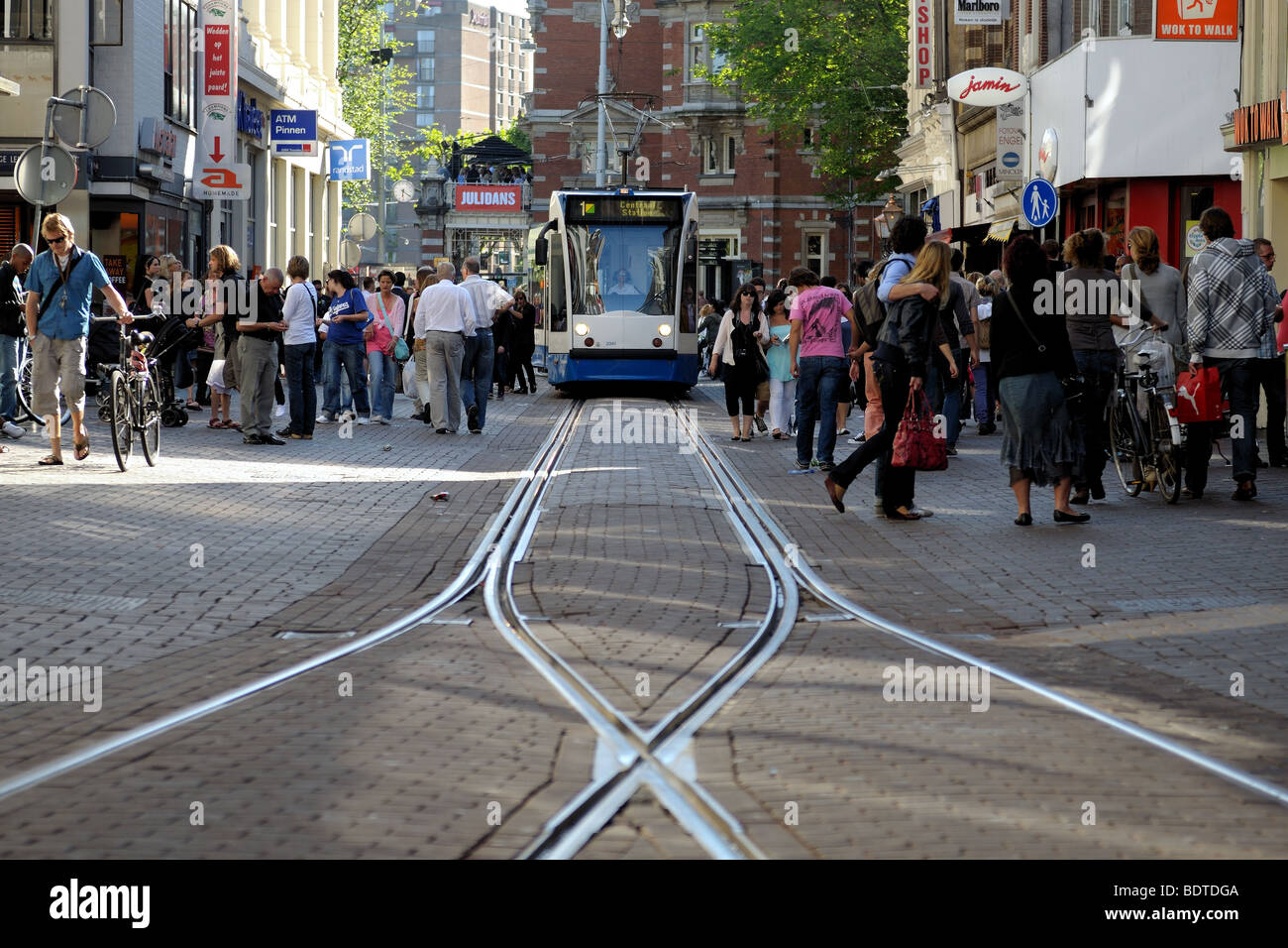 Il tram costringendo il suo modo attraverso strade affollate di Amsterdam. La suddivisione dei tram via Foto Stock