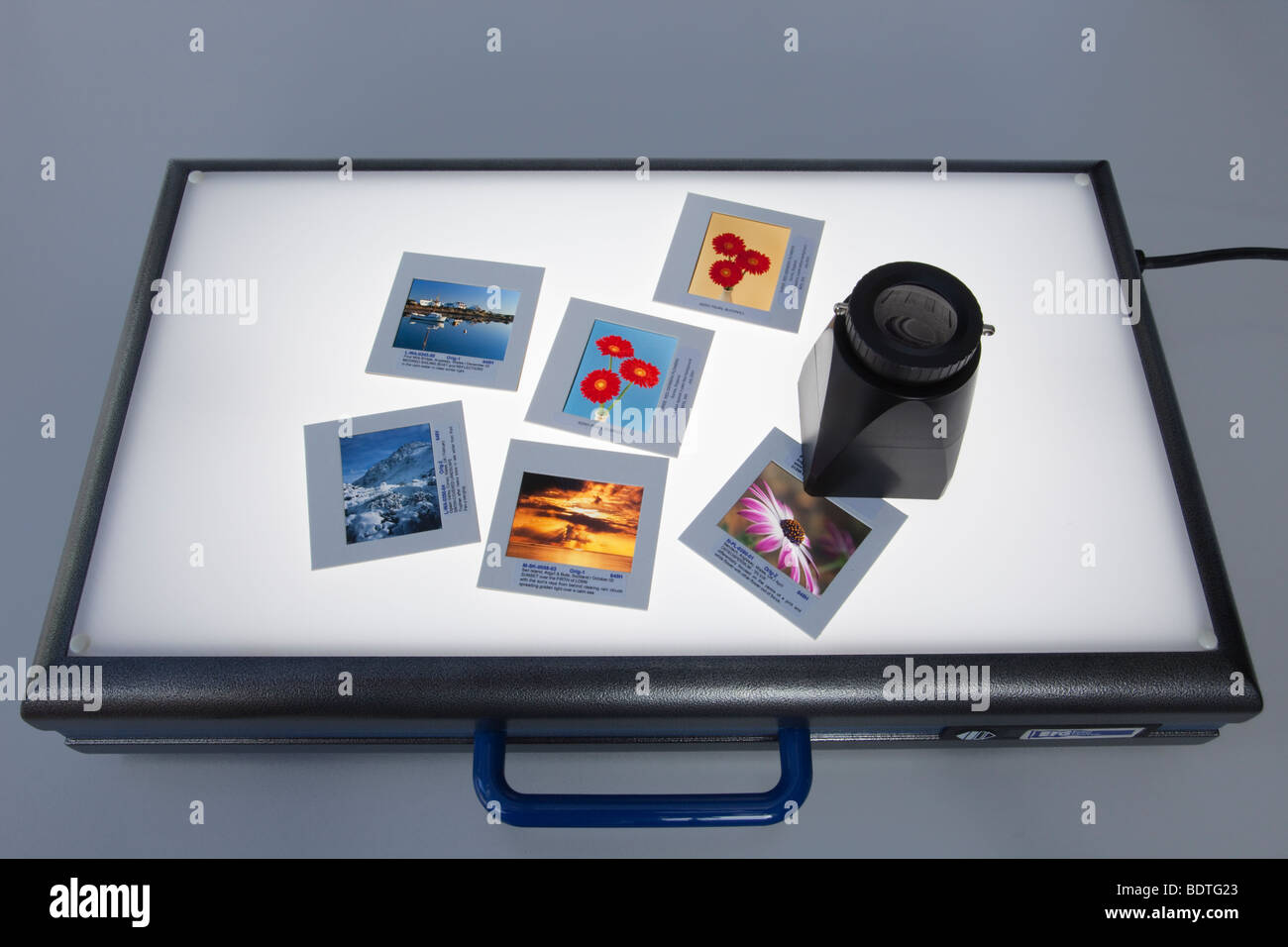 Formato del supporto di stampa per i lucidi e lente di ingrandimento su retroilluminato un lightbox illuminato Foto Stock