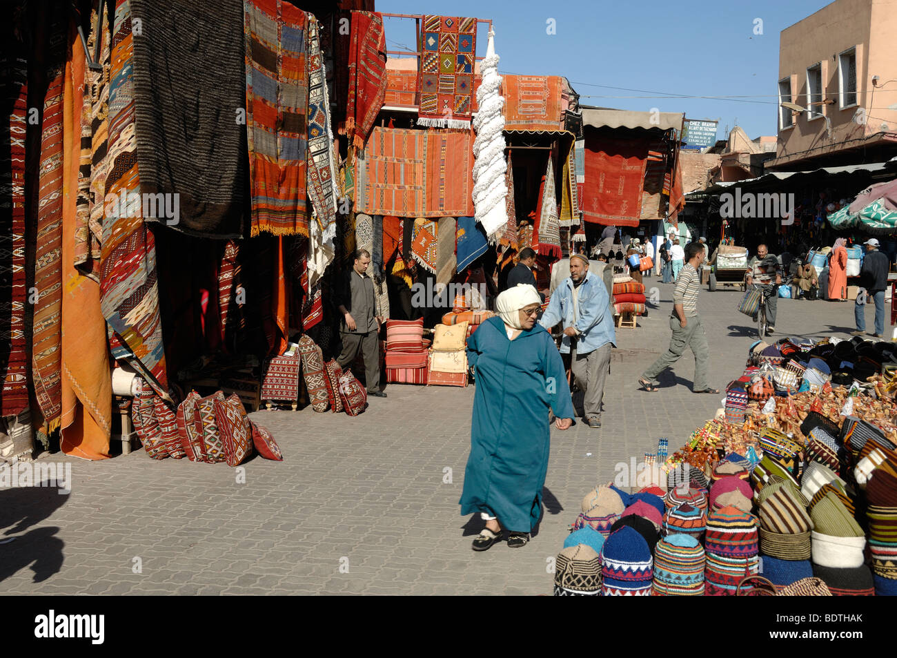 Una donna marocchina che indossa una sciarpa di testa nel tappeto Bazaar, mercato o souk, Place aux Epices, Marrakech, Marocco Foto Stock