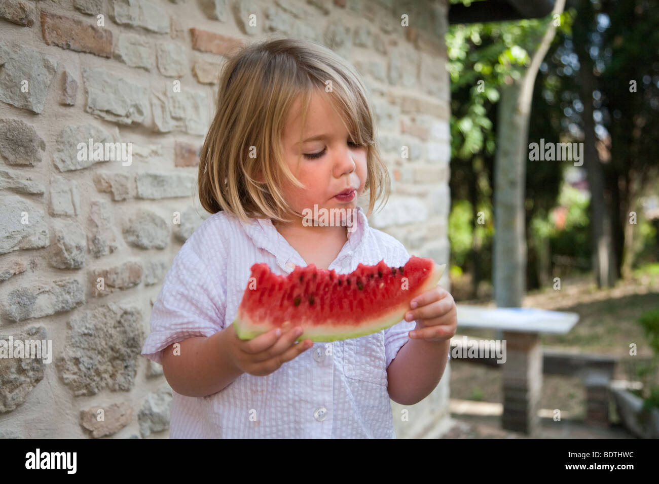 Ragazza bionda mangiando anguria Foto Stock