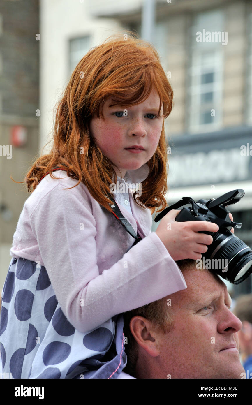 Ragazza giovane con la fotocamera sulle spalle dei padri a Bristol mezza maratona, REGNO UNITO Foto Stock