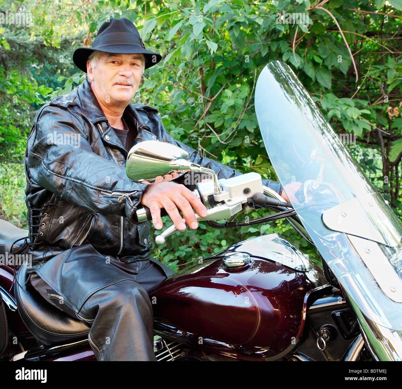 Un uomo di mezza età è in sella a una motocicletta. Foto Stock