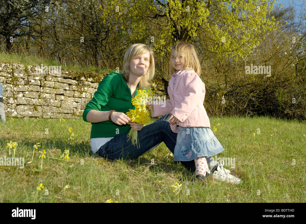 Donna e bambina aratro cowslip, Frau und Maechen pfluecken Schluesselblumen, Primula veris Foto Stock