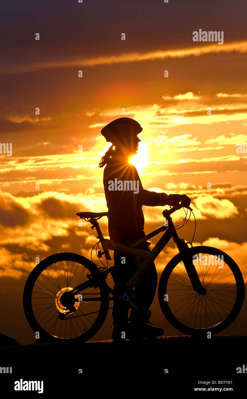 Femmina ciclista in discesa al sole di mezzanotte, Lapponia, Svezia Foto Stock