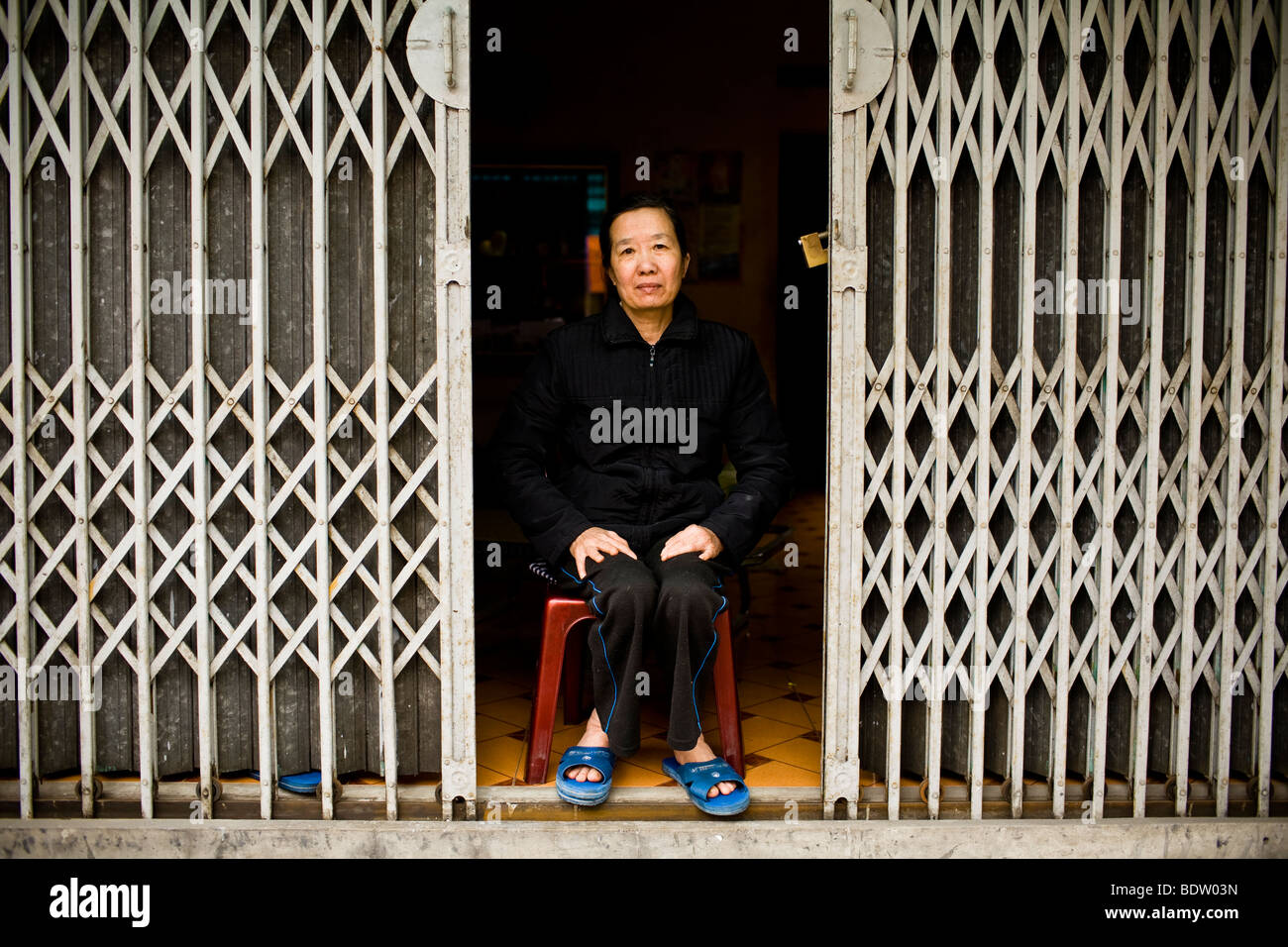 Una donna si siede per un ritratto nella sua casa di Hanoi, Vietnam Foto Stock