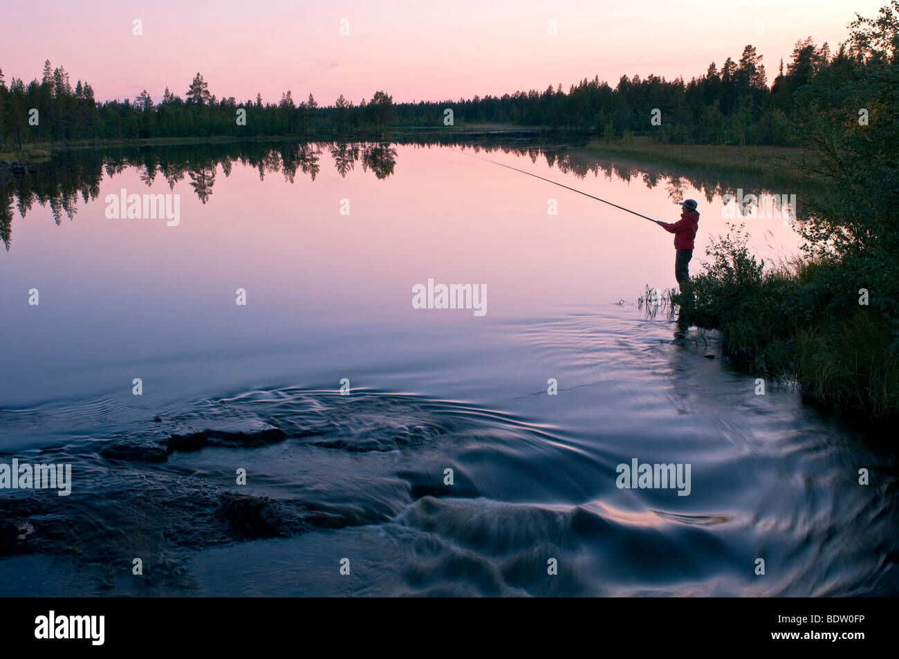 In anglerin abenddaemerung am vedere in lappland, SCHWEDEN, femmina pescatore a sundwon presso il lago in Lapponia svedese Foto Stock