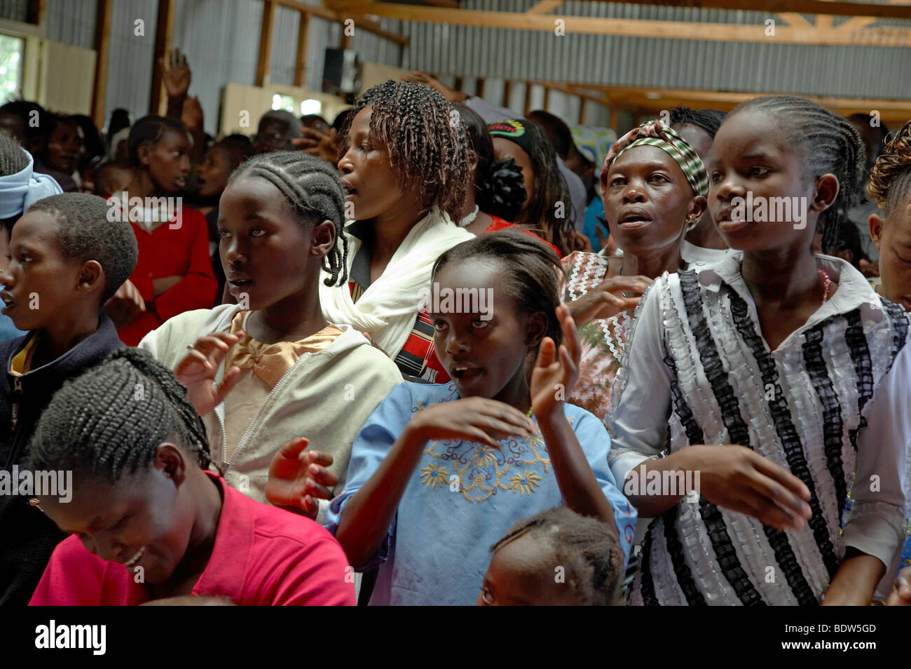 KENYA facce della congregazione alla messa cattolica in Mukuru Ruben, una delle baraccopoli di Nairobi. Canti e Balli. Foto Stock