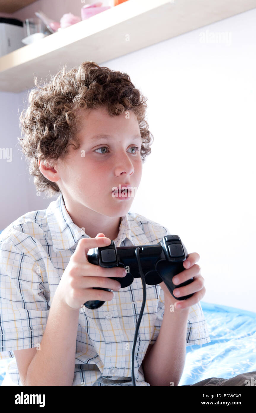 Giovane ragazzo giocando giochi per computer su Sony Playstation, England, Regno Unito Foto Stock