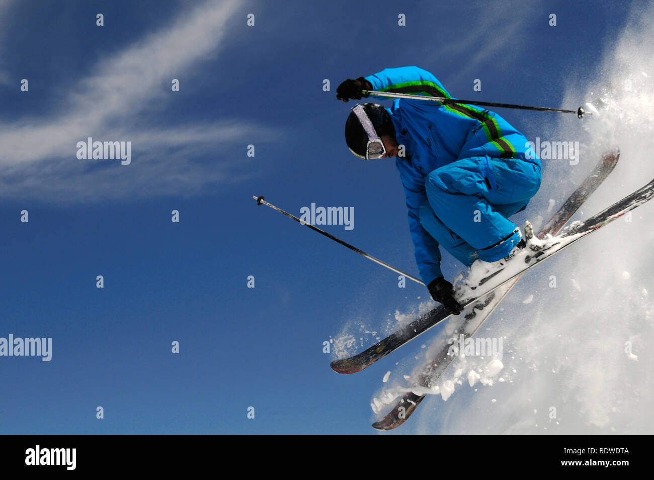 Sciatore il salto con gli sci incrociati su un blu scuro dello sfondo del cielo. Foto Stock