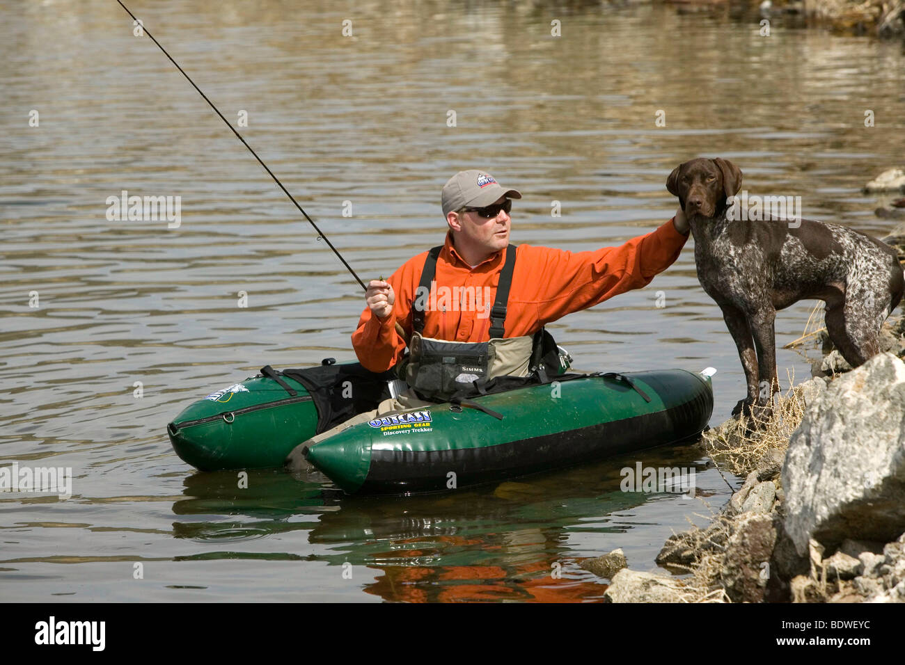 (MR) un pescatore di animali domestici il suo cane sul litorale, Foto Stock