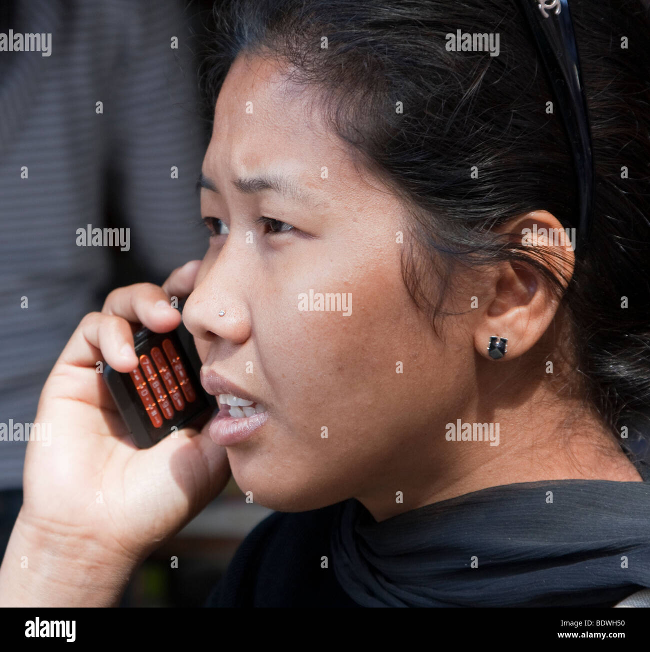 Kathmandu, Nepal. Giovani nepalesi donna tramite telefono cellulare. Nota diamond naso-pin. Foto Stock