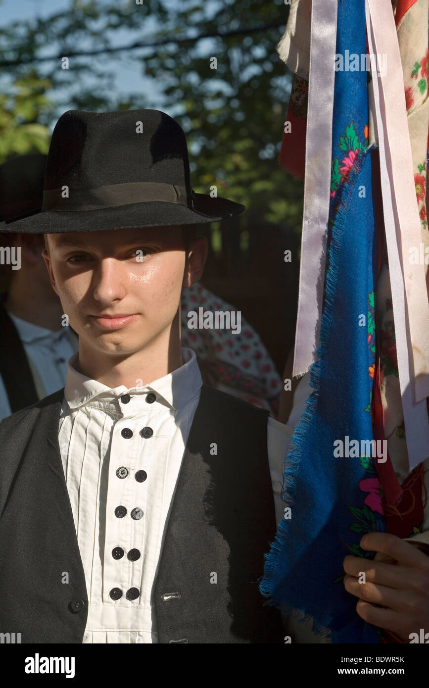 Una gioventù in costume tradizionale contiene un flag durante un evento di musica folk a Pecs, Ungheria Foto Stock