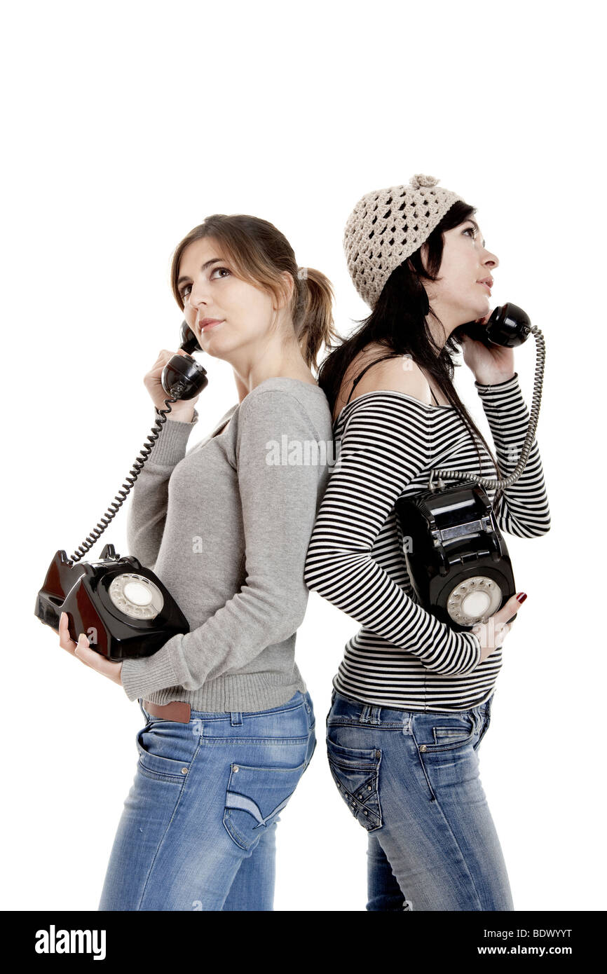 Due giovani donne a parlare con i vecchi telefoni - Isolato su bianco Foto Stock