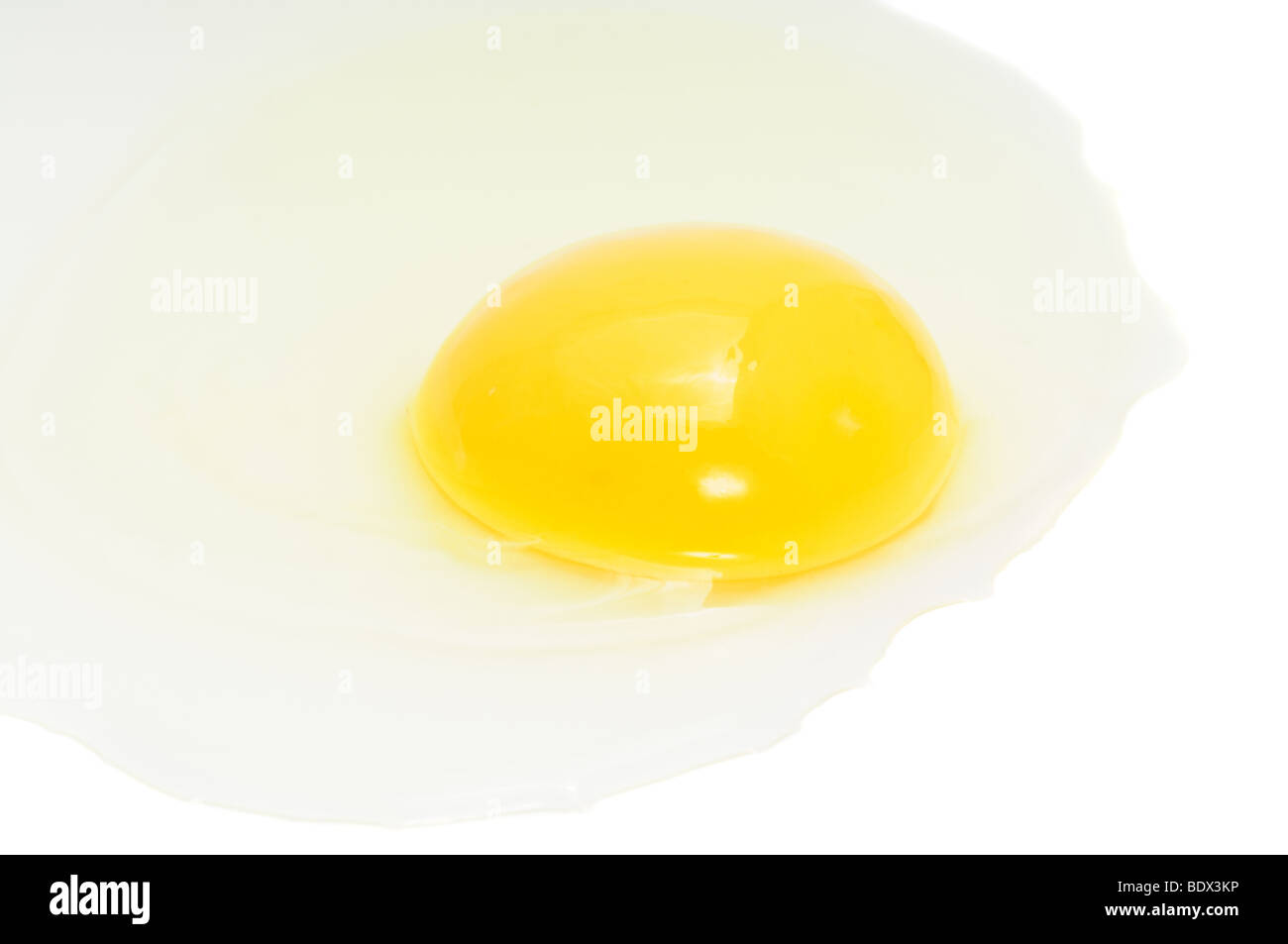 Incrinato uovo di pollo, concentrarsi sul tuorlo, isolato su bianco Foto Stock