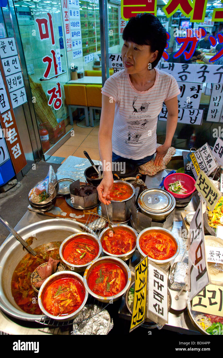 Donna piccante cucina Beltfish jiggae o stufato nel mercato Namdemun in Seoul COREA DEL SUD Foto Stock