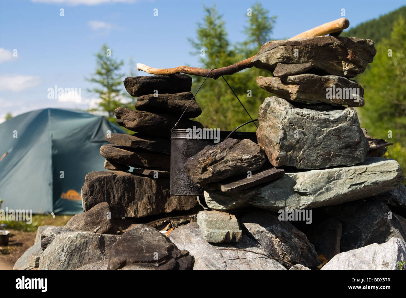 Suola fatta di pietre con coppa fissato pronto per aprire il fuoco per la cottura in un campo Foto Stock