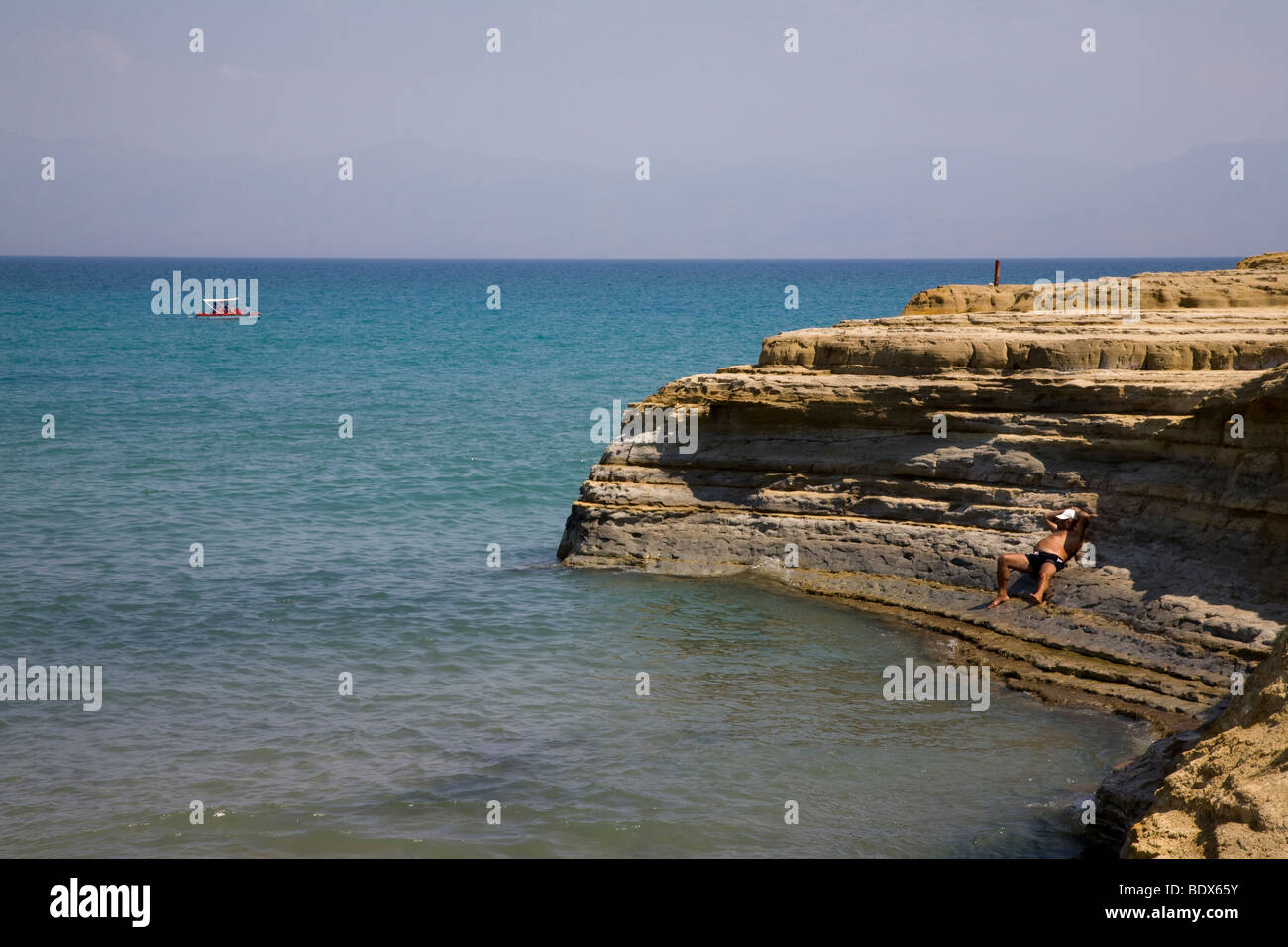 Sun bagnante sulle rocce. Sidari, Corfù, Grecia. Nessun modello di rilascio Foto Stock