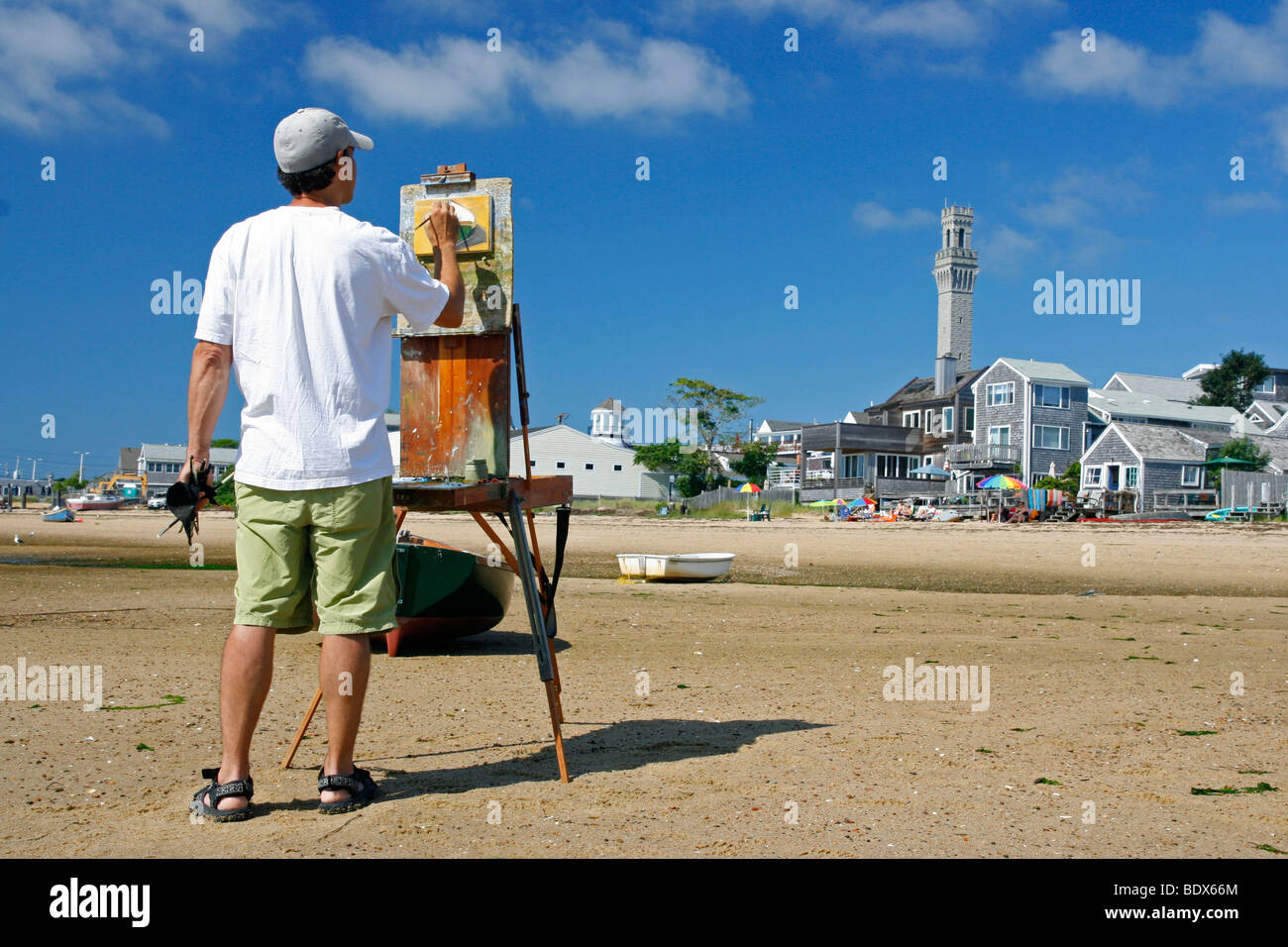 Artista maschile pittura una barca sulla spiaggia a Provincetown in Massachusetts. Foto Stock