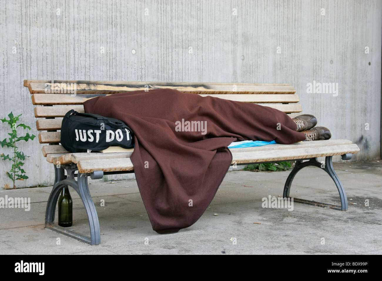 Un uomo senza dimora nel quartiere governativo di Berlino su una panchina del parco, Berlino, Germania, Europa Foto Stock