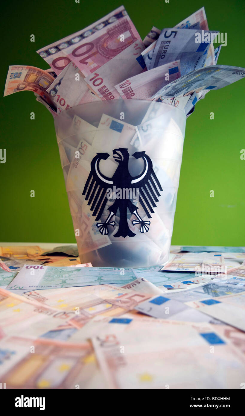 Cestino per la carta con aquila federale farcite con banconote Foto Stock