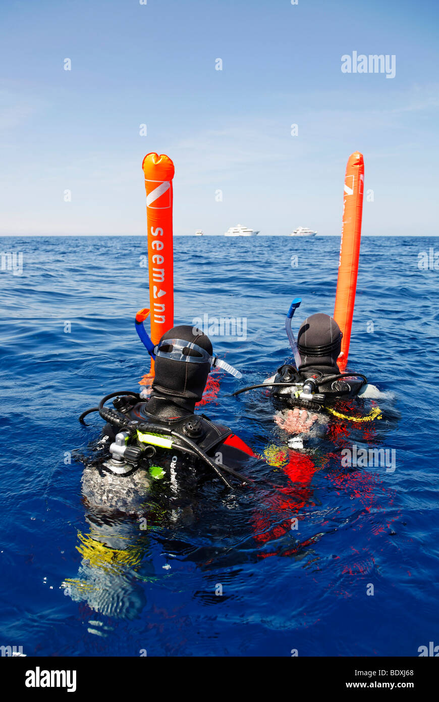 Il drifting subacquei in mare stanno tentando di ottenere l'attenzione di persone su navi di immersioni all'orizzonte con boe di sicurezza, Egitto, Mar Rosso Foto Stock