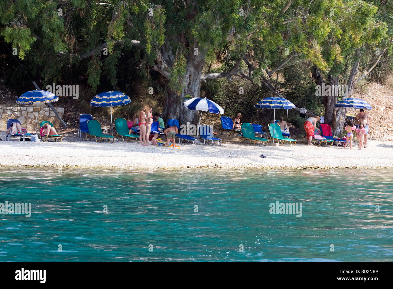 Una giornata in spiaggia. Famiglie e ombrelloni. Corfù, Grecia. Nessun modello di release. Foto Stock
