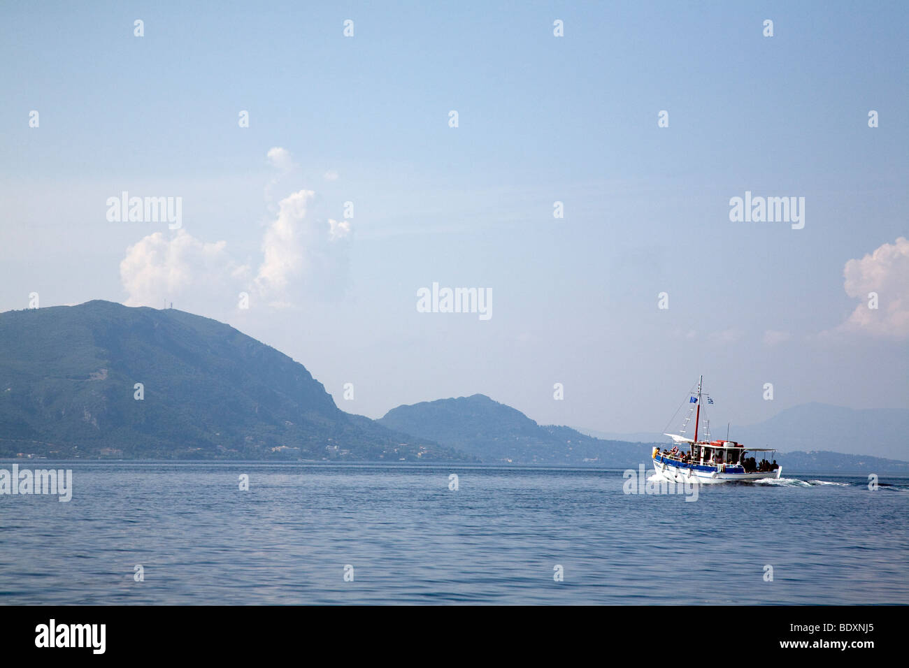 Imbarcazione turistica prima che le montagne di Corfù. La Grecia. Nessuna proprietà release. Nessun modello di rilascio Foto Stock