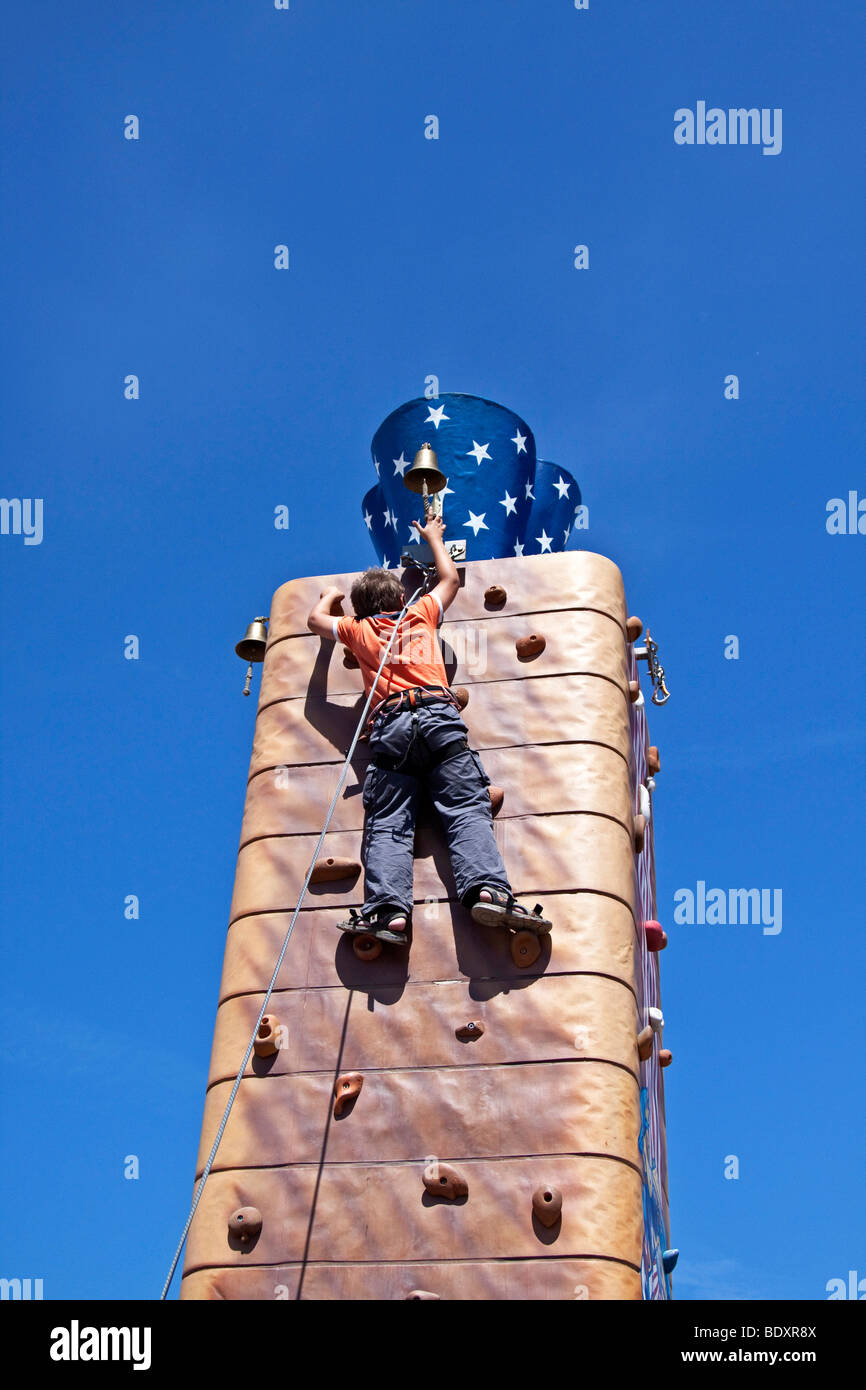 Ragazzo la scalata di una parete di arrampicata Foto Stock