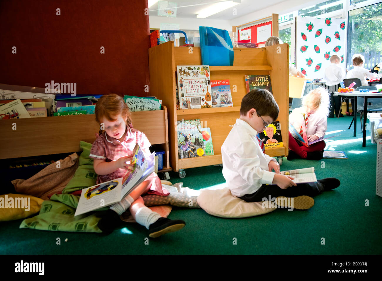 Tre bambini la lettura di libri in una classe Foto Stock