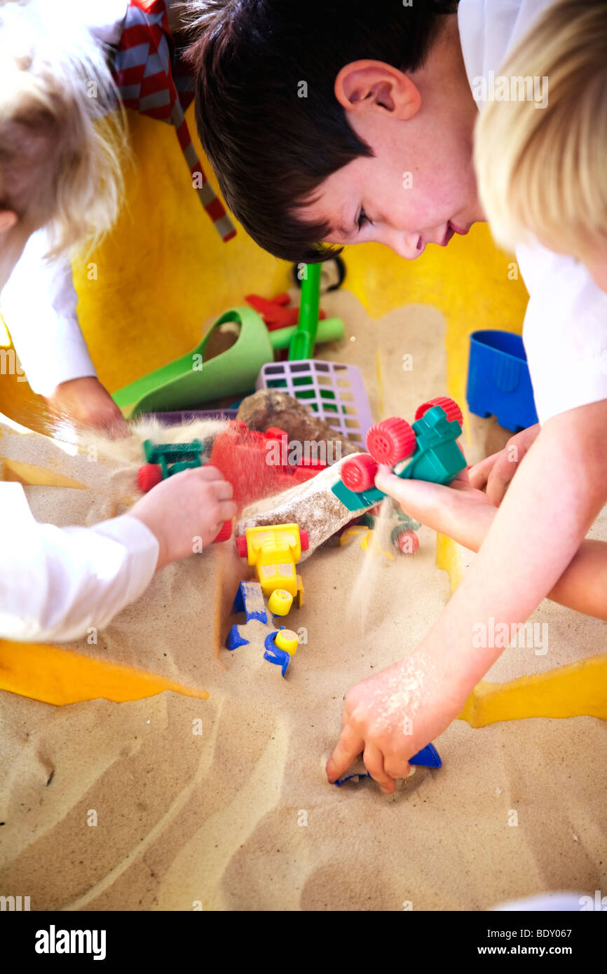 Bambini che giocano in una buca di sabbia Foto Stock