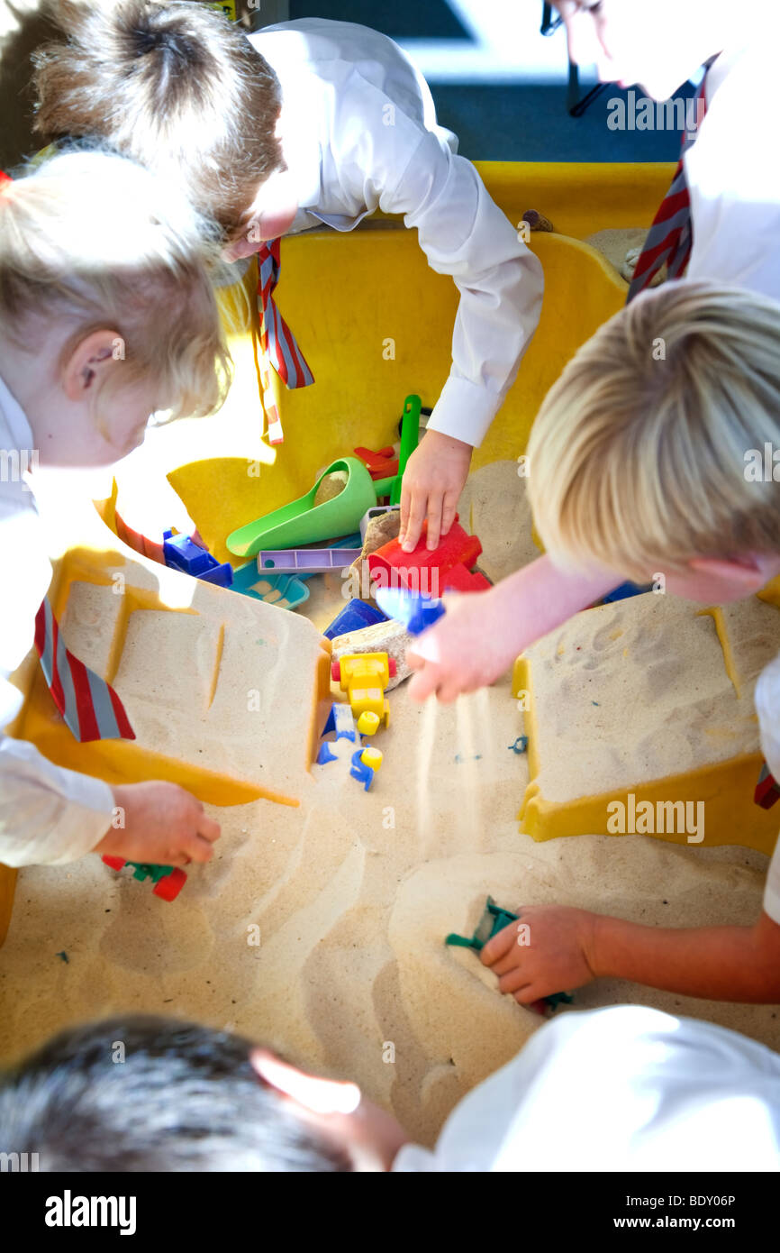 Fase di fondazione dei bambini che giocano in una buca di sabbia Foto Stock