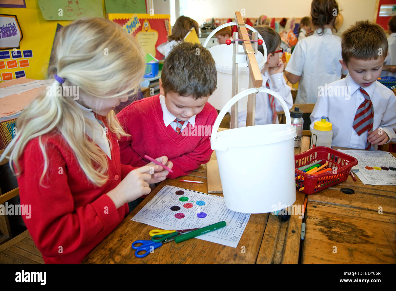 I bambini in un Regno Unito la scuola primaria facendo un esperimento scientifico Foto Stock