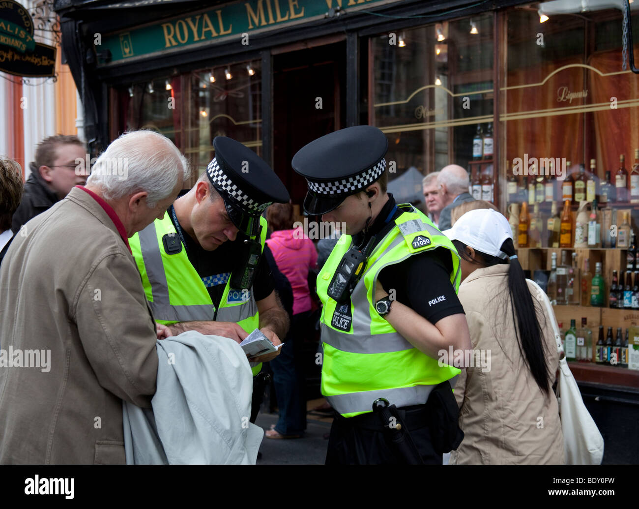 Due funzionari di polizia di sesso maschile aiutare l uomo con le direzioni, Royal Mile di Edimburgo in Scozia UK Europa Foto Stock