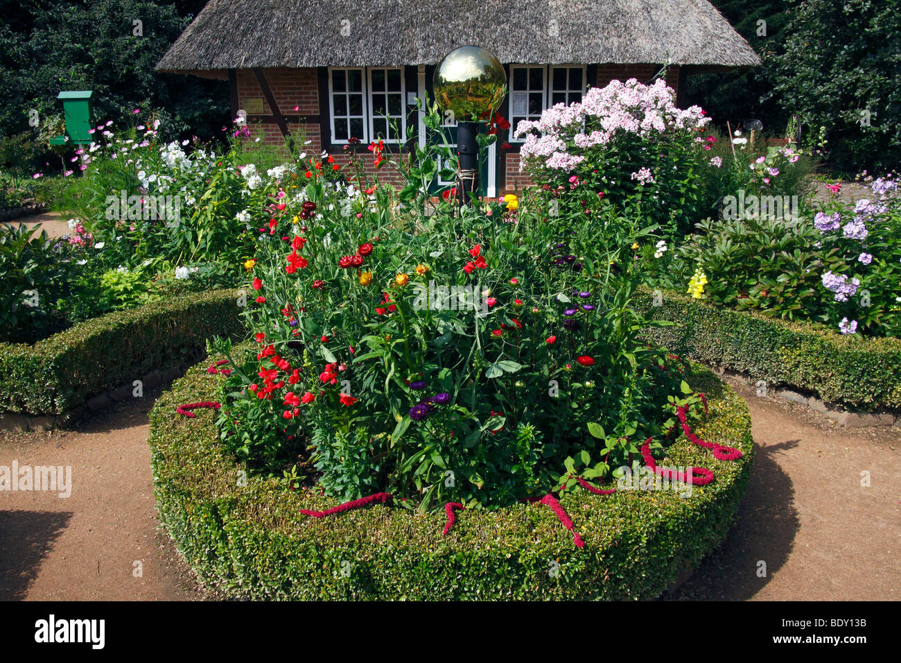 Basso tedesco giardino cottage con un rondel, siepe di bosso, giardino phlox (Phlox paniculata) e altri fiori estivi, Giardino Botanico Foto Stock