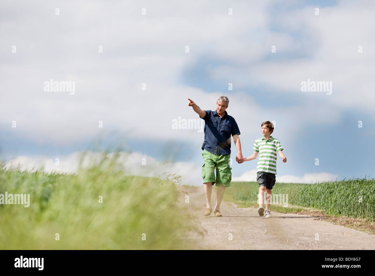 Padre e figlio a piedi lungo una strada Foto Stock