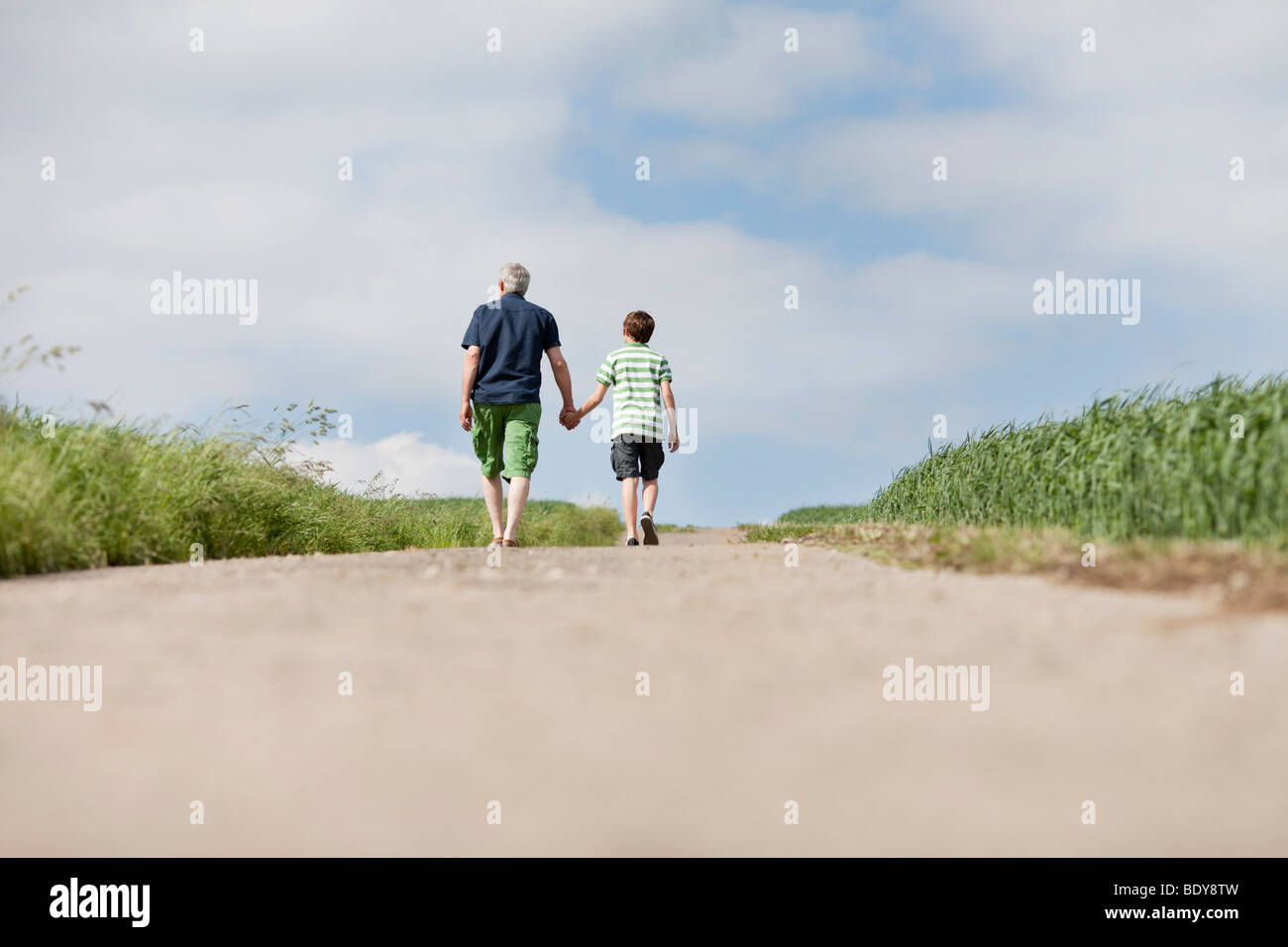 Padre e figlio a camminare su una strada Foto Stock