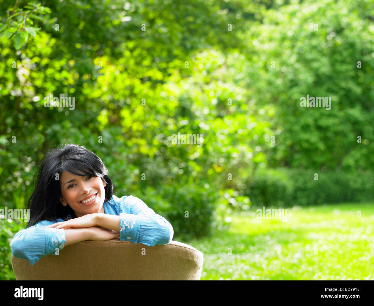 Donna sul divano, in giardino Foto Stock