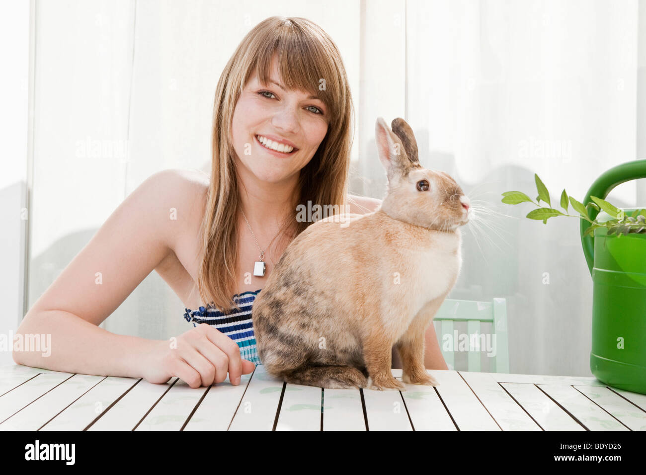 Giovane donna e un coniglio di pet su un patio Foto Stock