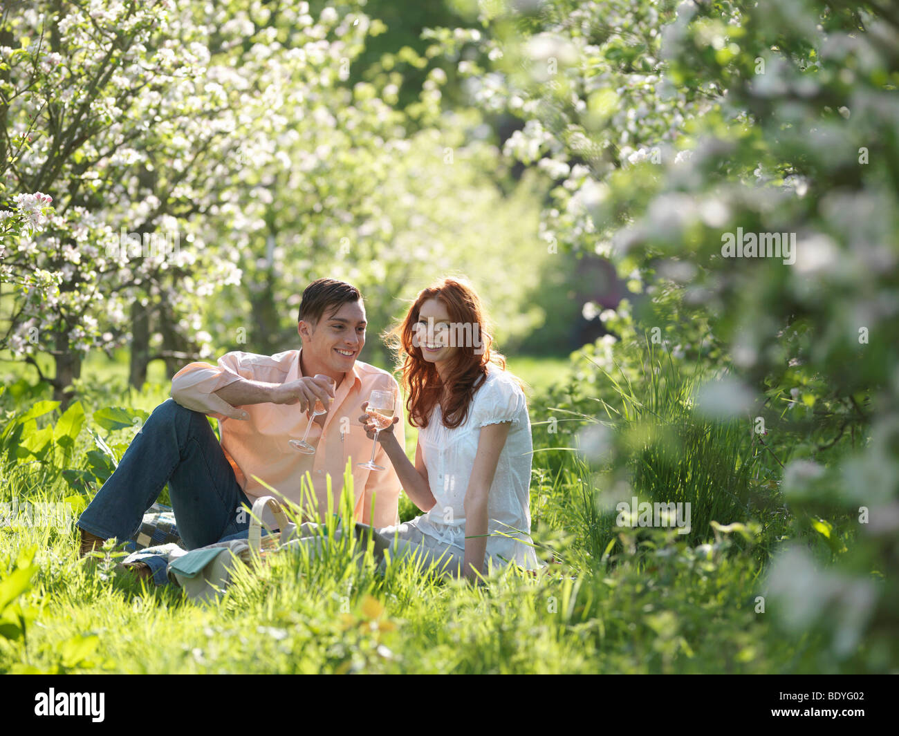 Giovane avente Picnic In Orchard Foto Stock