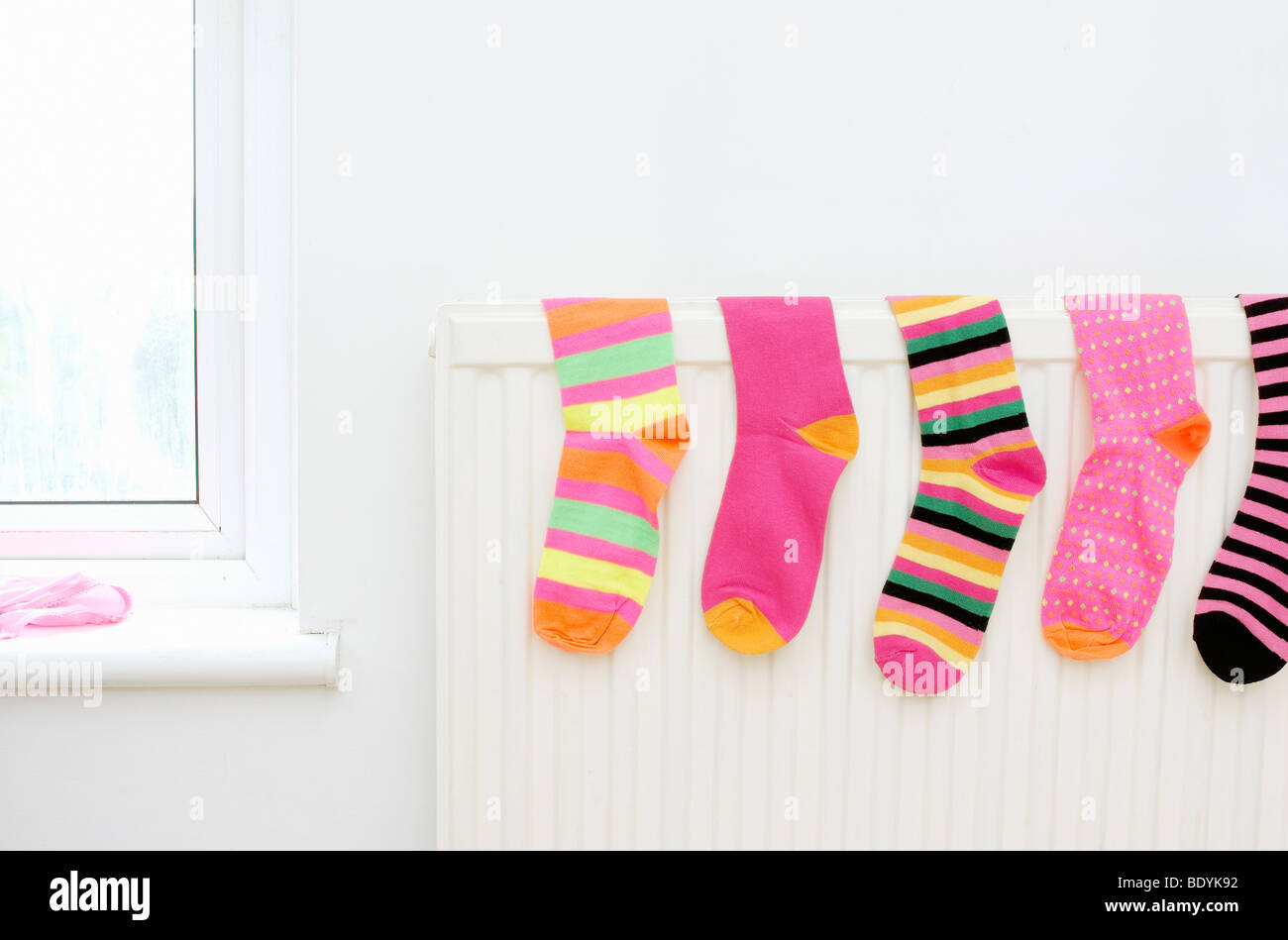 Calze colorate asciugatura sul radiatore Foto Stock