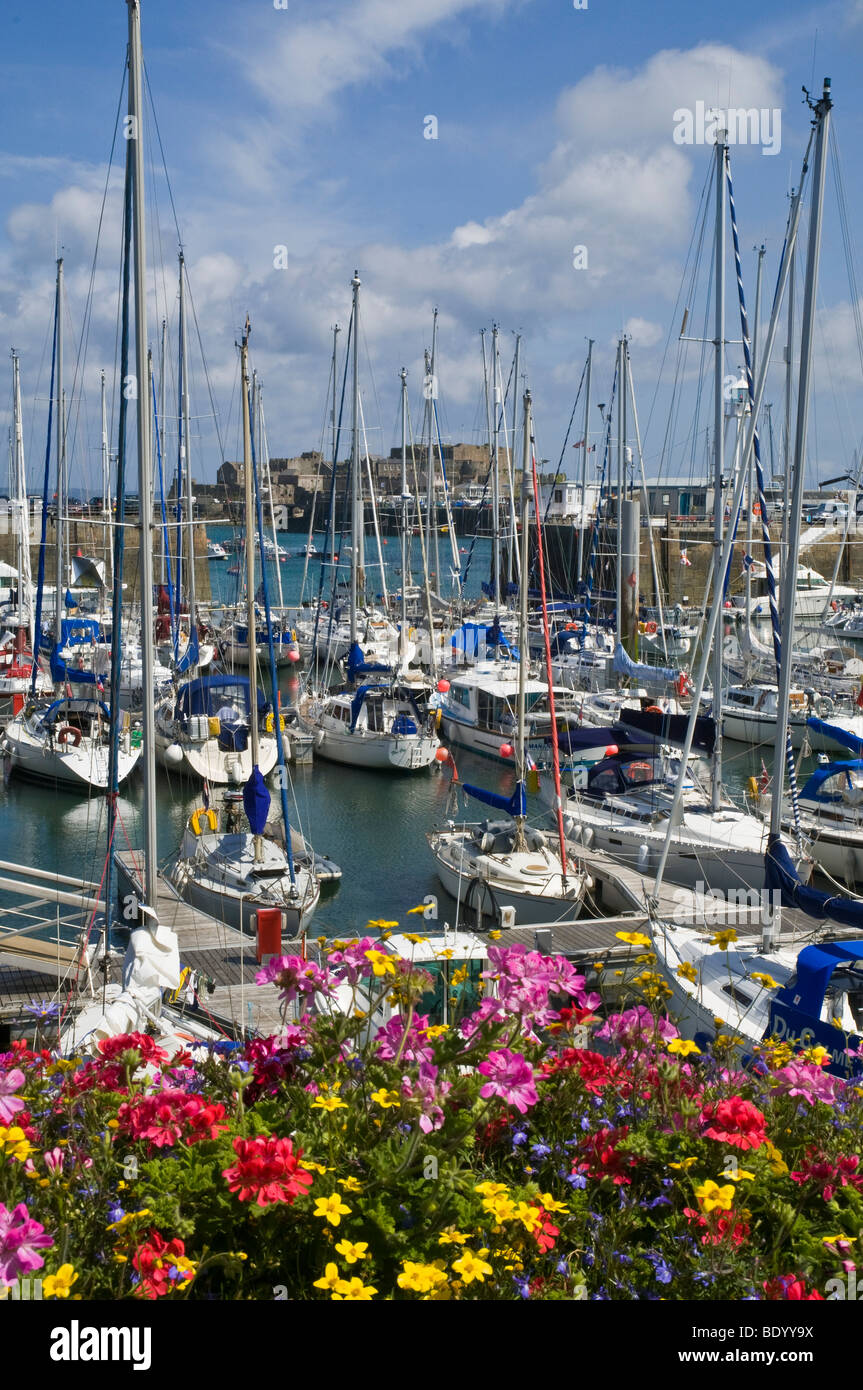dh Harbour ST PETER PORT GUERNSEY St Peters Port yacht fiori barche marina in sole isole canale Foto Stock