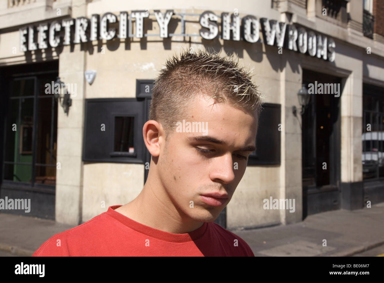 Giovane con impulso breve di capelli corti al di fuori dell'elettricità Showroom bar a Hoxton, Londra Foto Stock
