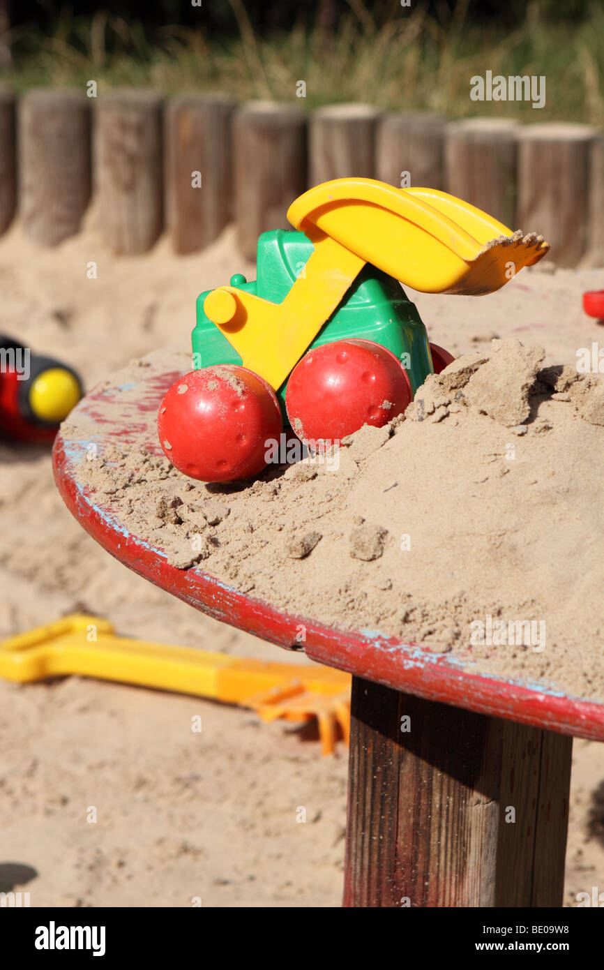 Giocattoli per bambini in una buca di sabbia area di gioco Foto Stock