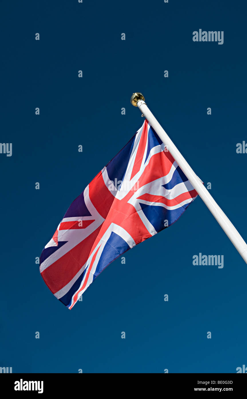 Un union jack bandiera britannica sventolare nel vento su un palo in un modo patriottica Foto Stock